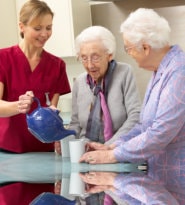 Caregiver serving tea to patient