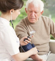 Nurse monitoring blood pressure of patient